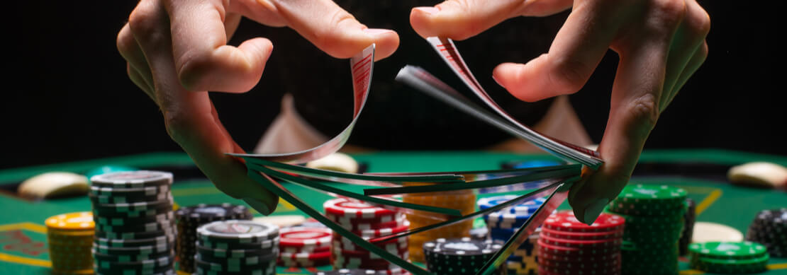 dealer shuffling cards at a poker table with chips