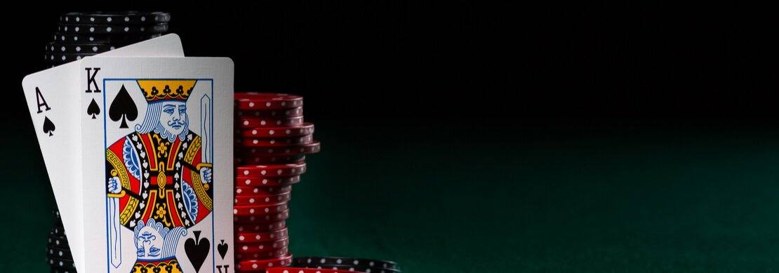 a blackjack hand next to a pile of casino chips 