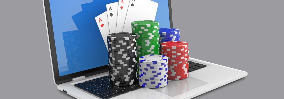laptop computer screen showing 4 Aces with cards flying around and chips stacked on the table