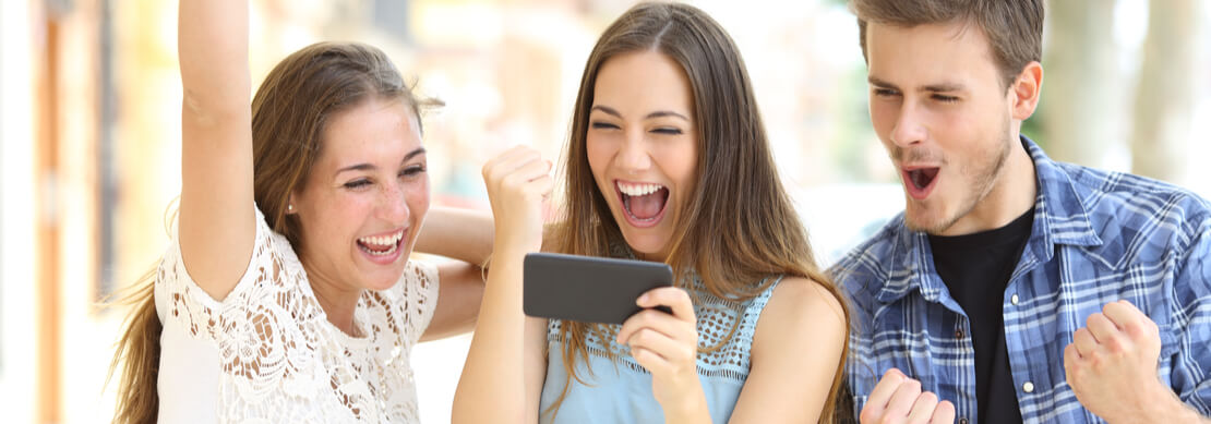 three friends cheering a win playing at Jackpot Capital on the phone