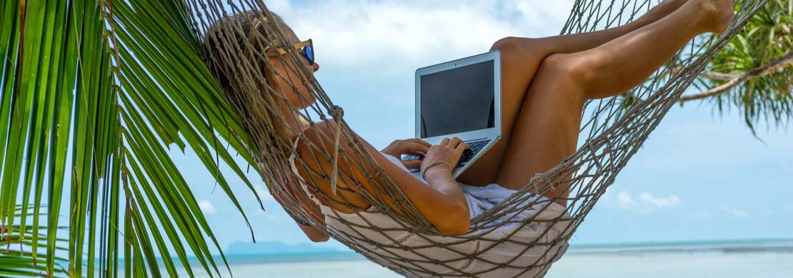 woman playing at Jackpot Capital while lounging in a hammock on the beach