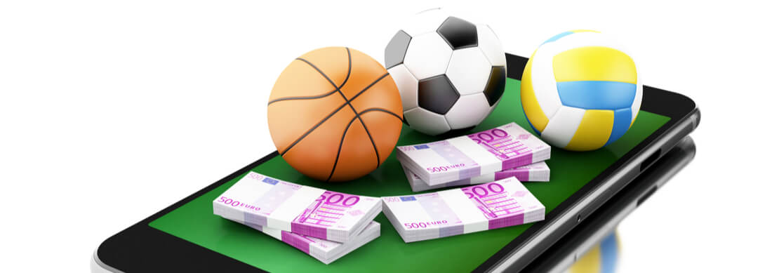 a mobile phone with soccer ball, basketball and cash sitting on it