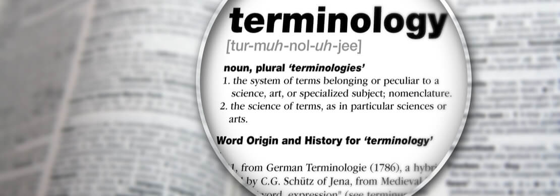 dictionary opened on the table with a magnifying glass on the word Terminology