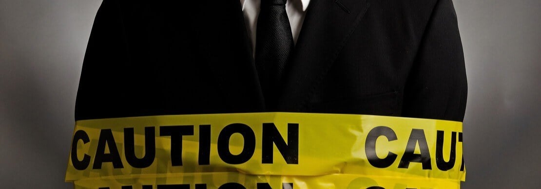 man in a suit with a "caution" tape wrapped around his body