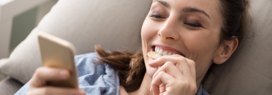 gamer playing on her phone with snacks