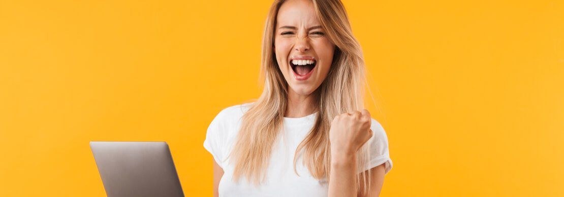 woman holding her laptop looking very happy