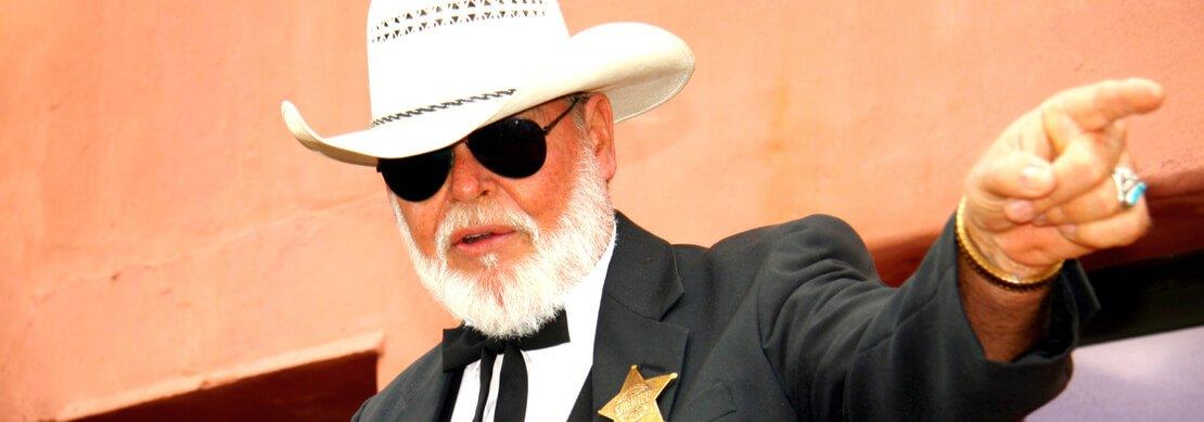 a photo of Kenny Rogers with sunglasses and a white cowboy hat