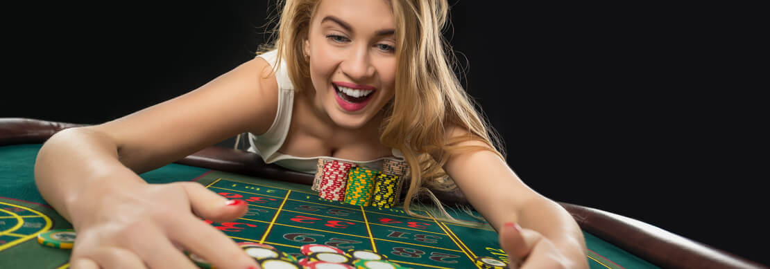 woman raking in a pile of chips after a Jackpot Capital roulette win