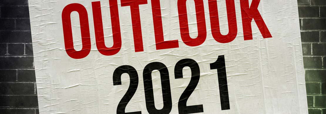 Outlook 2021 written on a poster and put on a brick wall