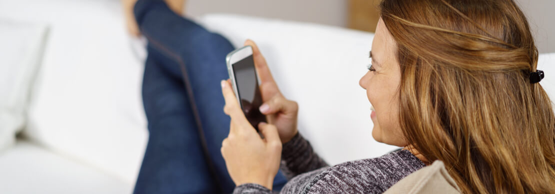 gamer on her cell phone relaxing on the sofa