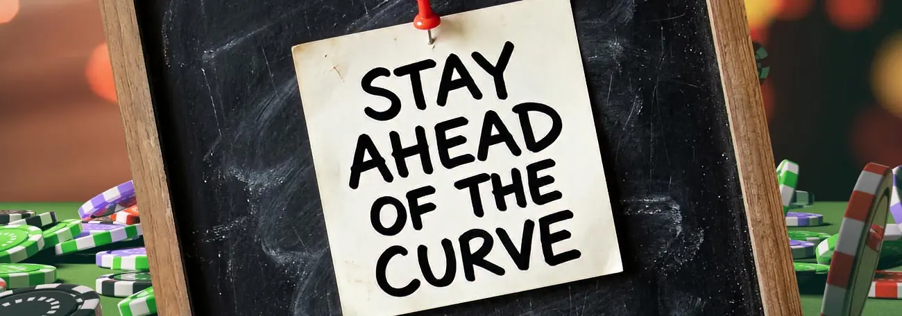 a small square of paper pinned to a chalk board with the words Stay Ahead of The Curve in bold black letters on it