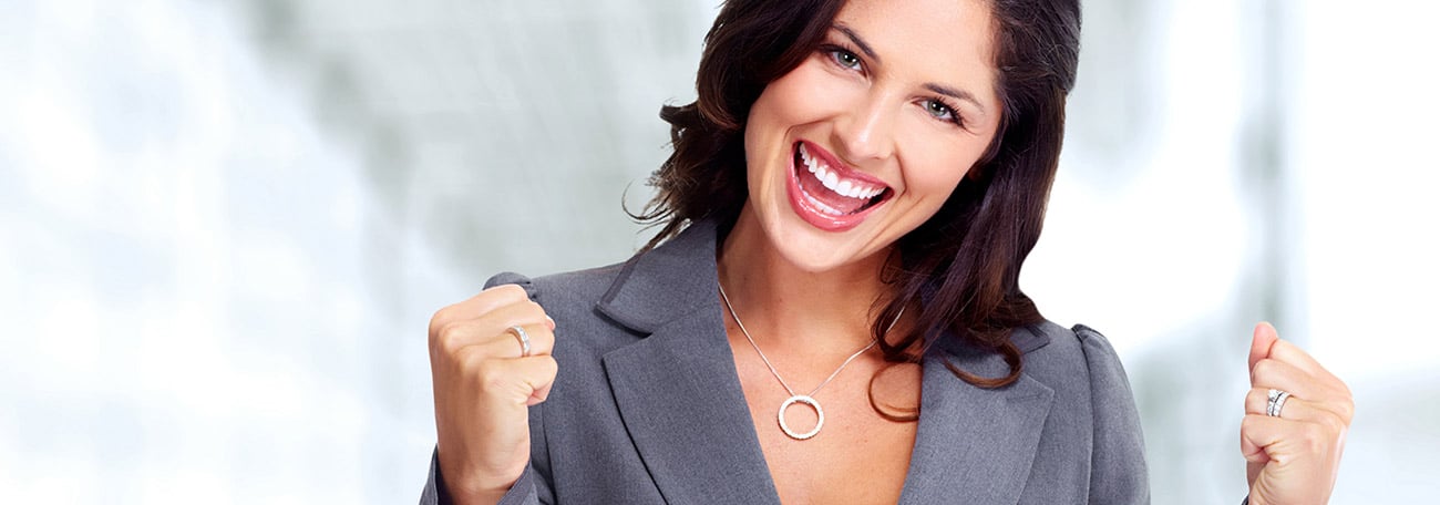 attractive woman in a business suit excitedly pumping her arms because she has finished a new bucket list