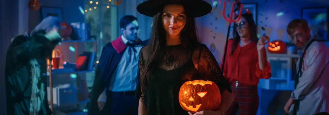 a Halloween party in progress with dimmed lights and party goers all in costume