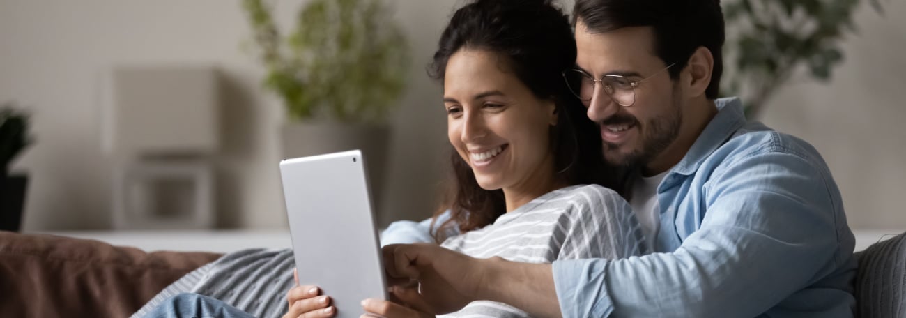 a young multi-ethnic couple reading from a tablet together