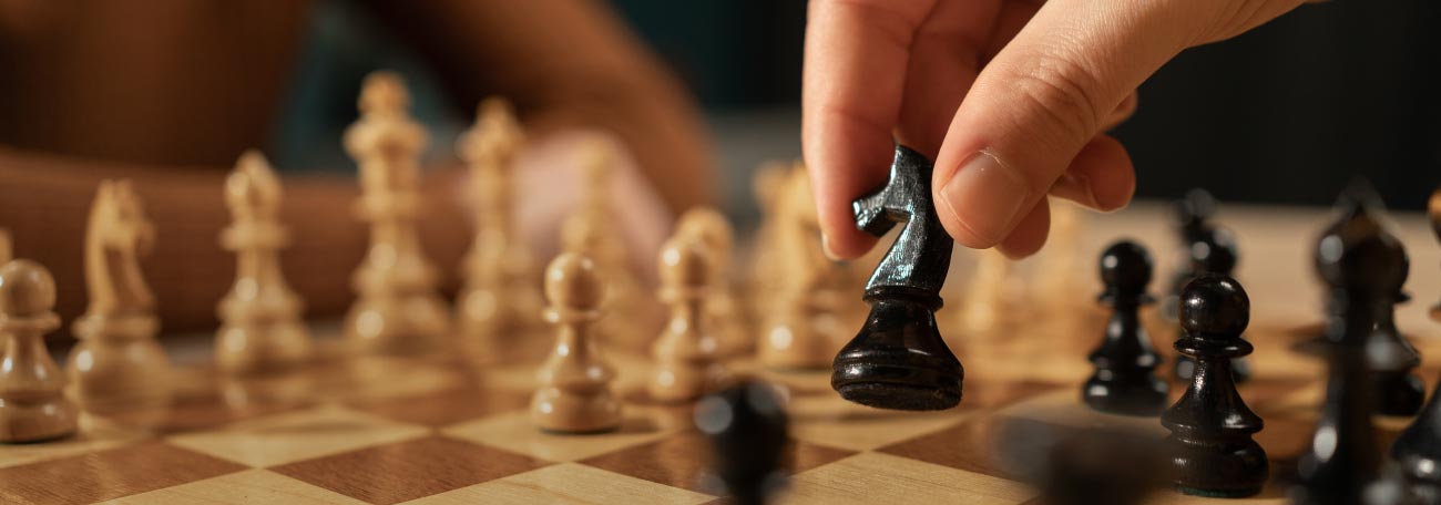 a man and a woman playing chess. The man is shown moving a piece.