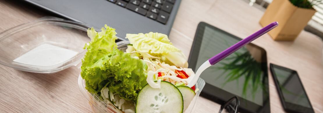 Woman eating a healthy salad for lunch at the office