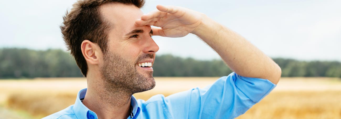 a young man in a field looking towards the horizon contemplating his next decision or the future in general