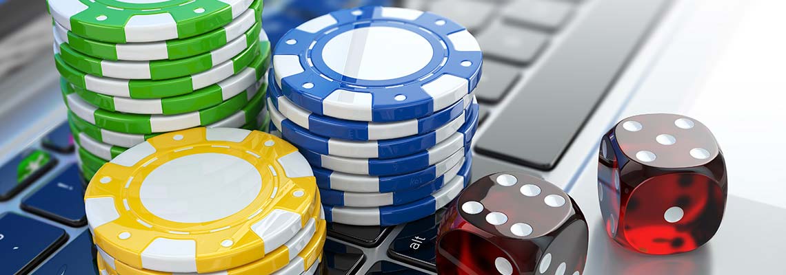 green, blue,and yellow casino chips and red dice on a keyboard
