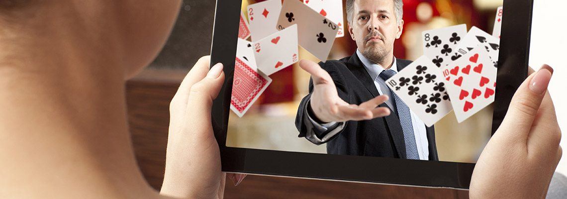 a young woman holding a tablet where a man is throwing playing cards that are coming out of the screen