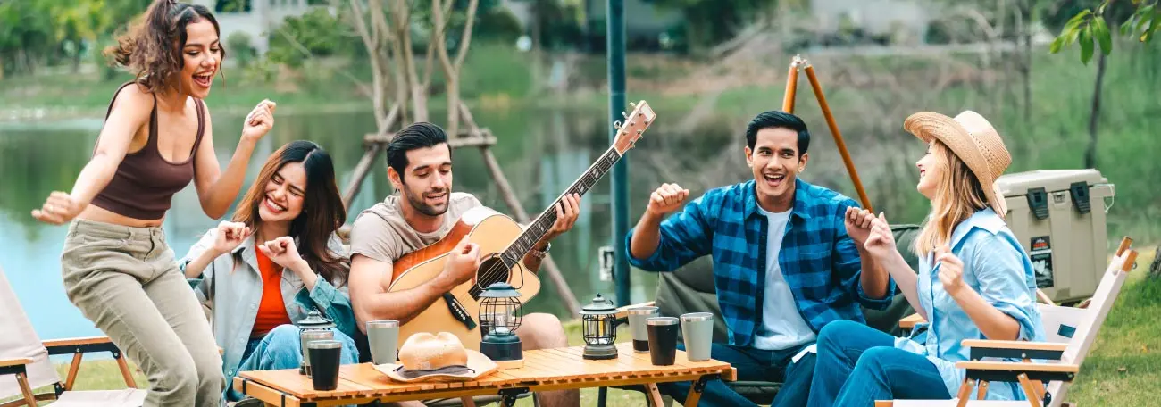 a group of three young women and two young men enjoying being together outdoors