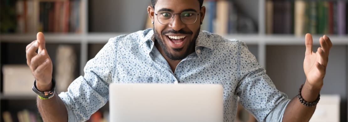 thirty something man at laptop reacts to winning a big jackpot at an online casino