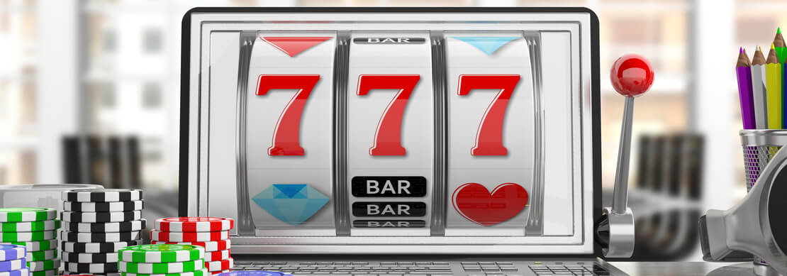a 777 slot game on a laptop with piles of casino chips around