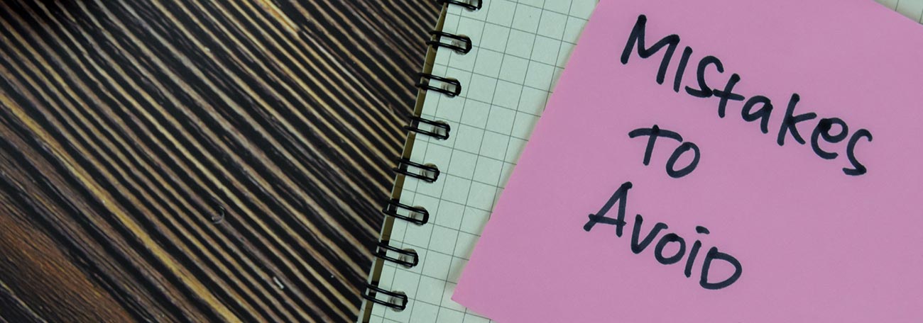 a purple stick'em with the words "mistakes to avoid" placed on an open notebook