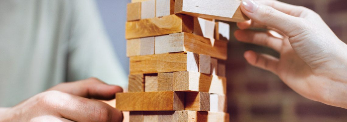 two hands playing jenga, game of skill