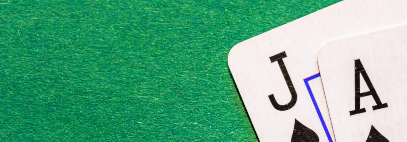 a blackjack of a 10 and ace of spades against a green felt background