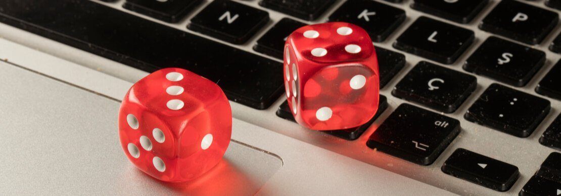 two red dice sitting on a laptop keyboard