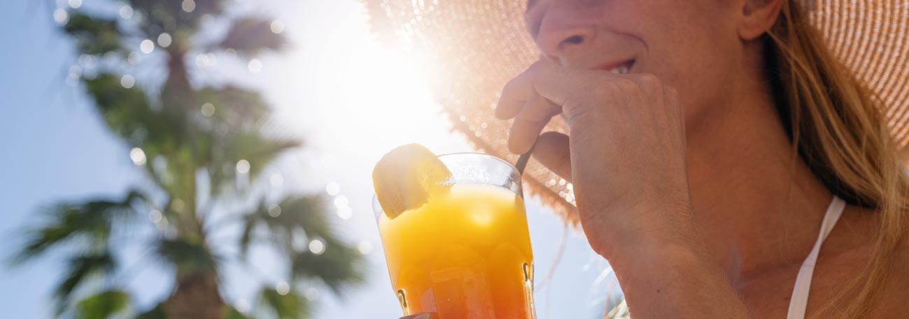 a woman enjoying a typical tropical drink on a Caribbean island